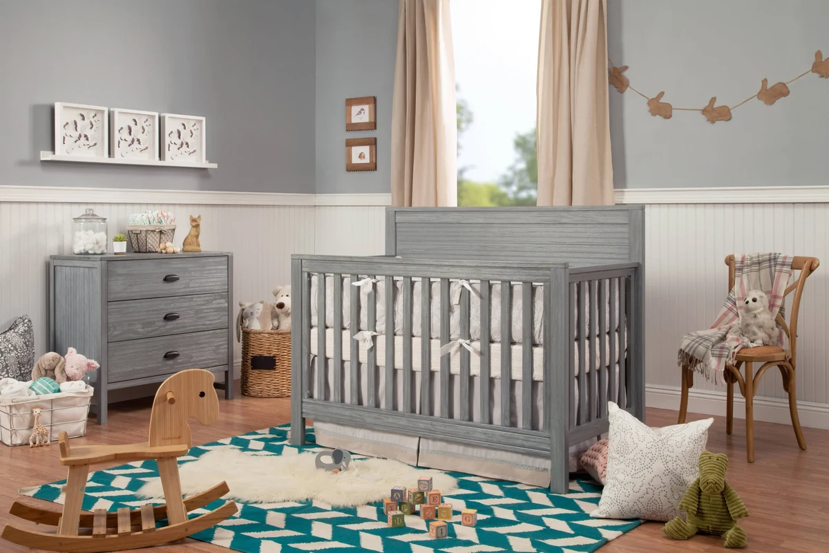 Clean nursery crib set up for a newborn with firm mattress and fitted sheet
